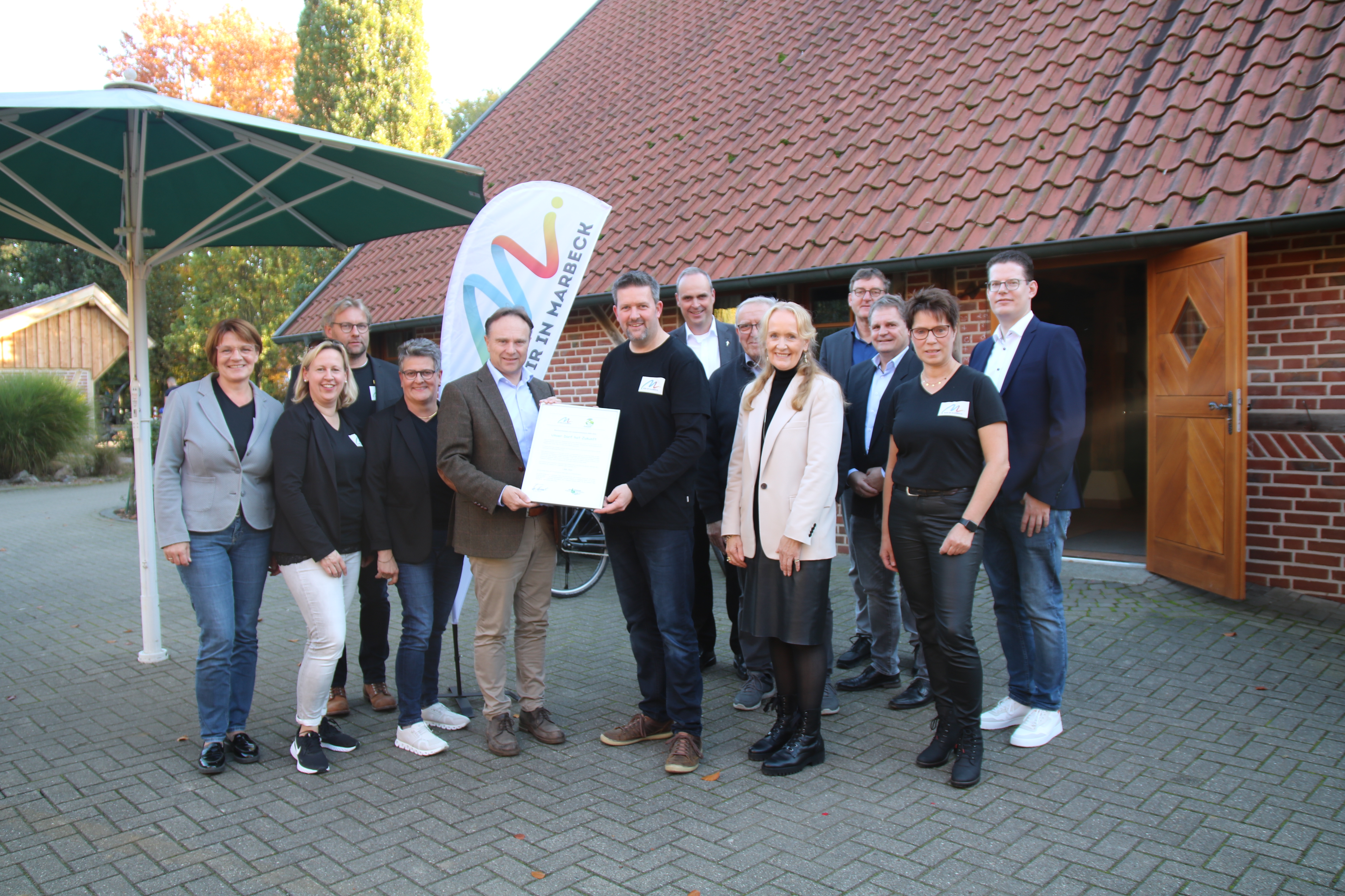 Landrat Dr. Kai Zwicker (5. v. l.) überreichte die Urkunde des Kreises - verbunden mit einem finanziellen Zuschuss - an Uwe Rottbeck von der Marbecker Initiative, rechts daneben (halbverdeckt) Ortsvorsteher Günter Stork und Bürgermeisterin Mechthild Schulze Hessing. 